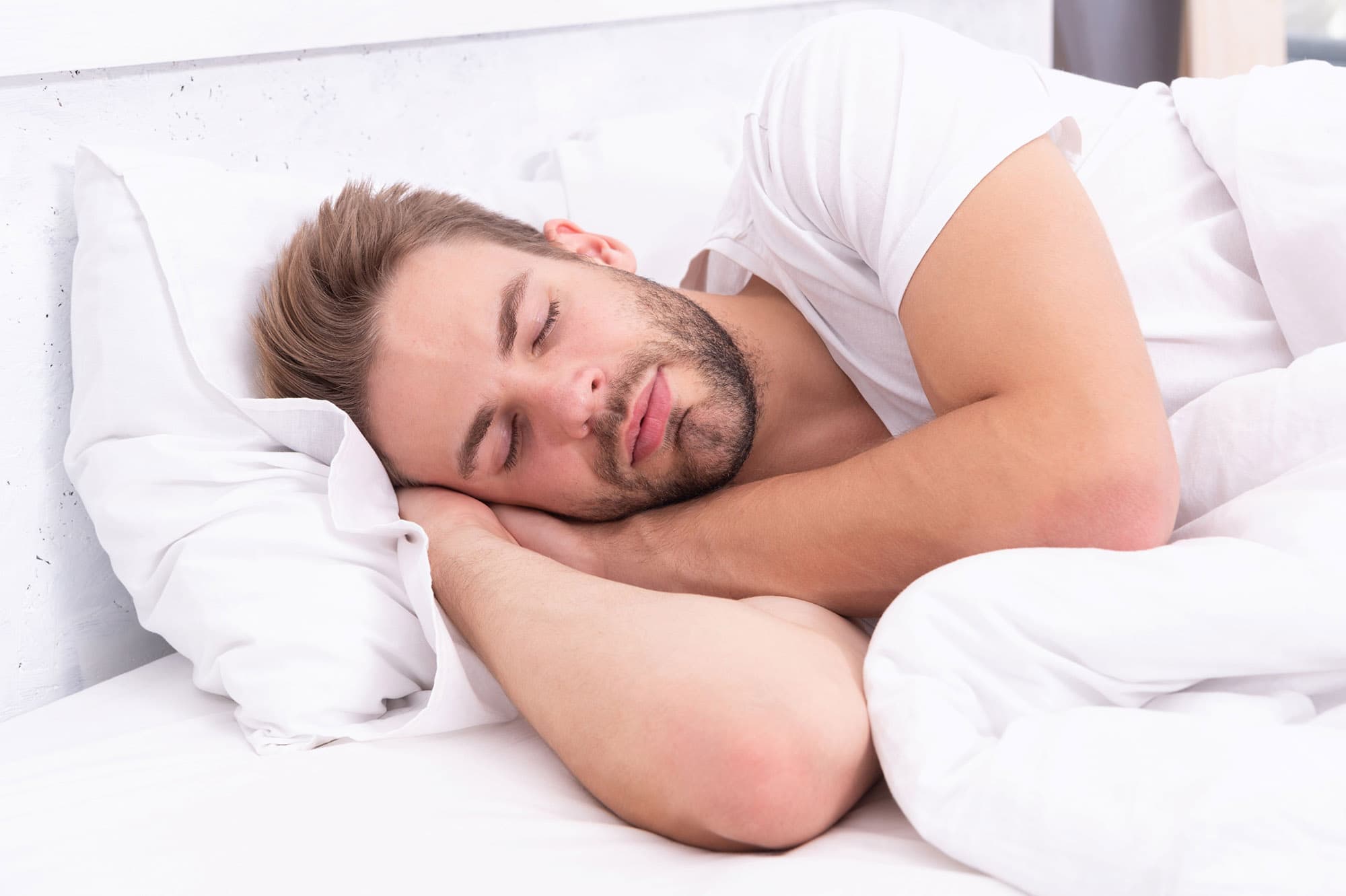 Man sleeping on his side with his head resting on his arm.