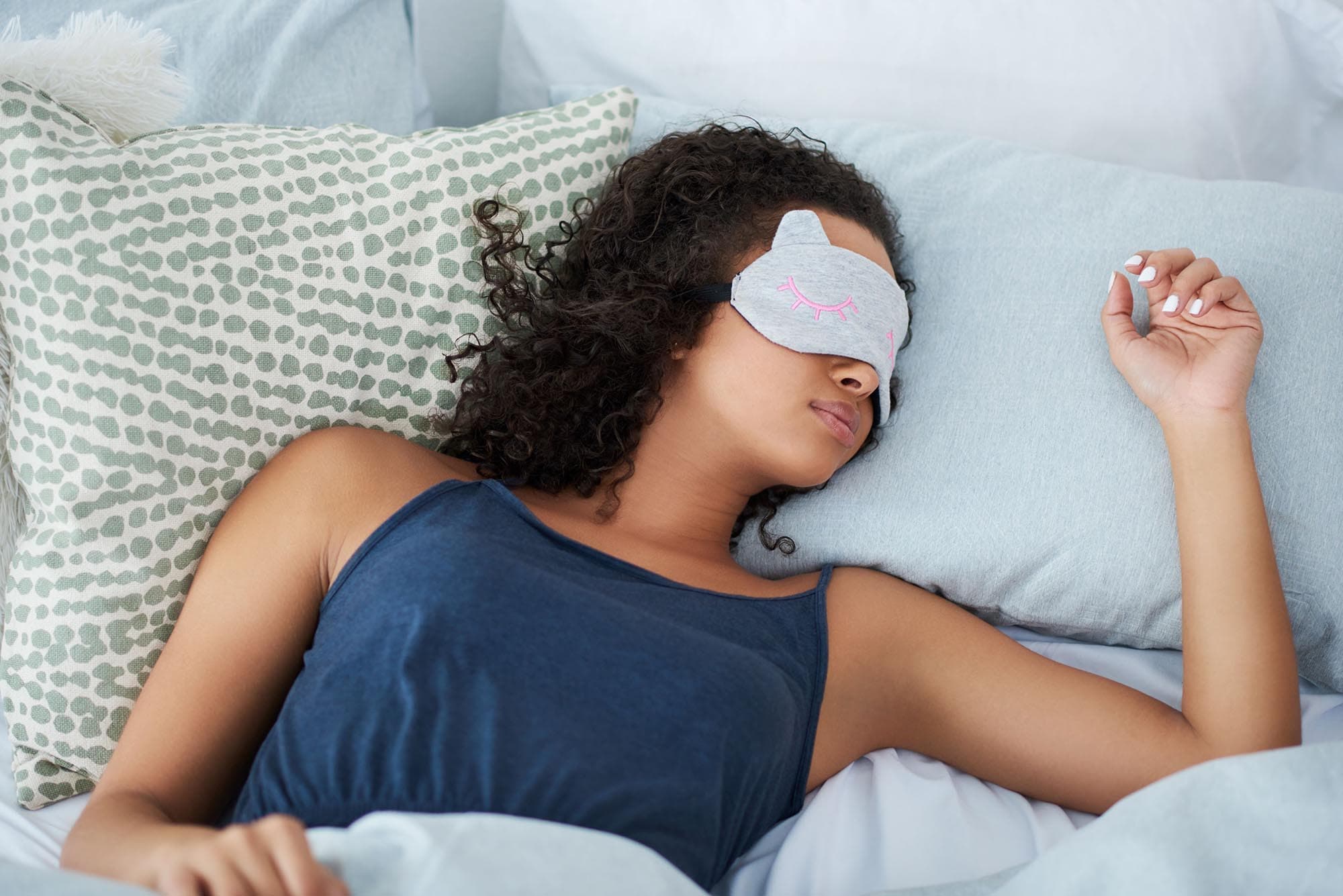 Woman napping with an eye mask on.