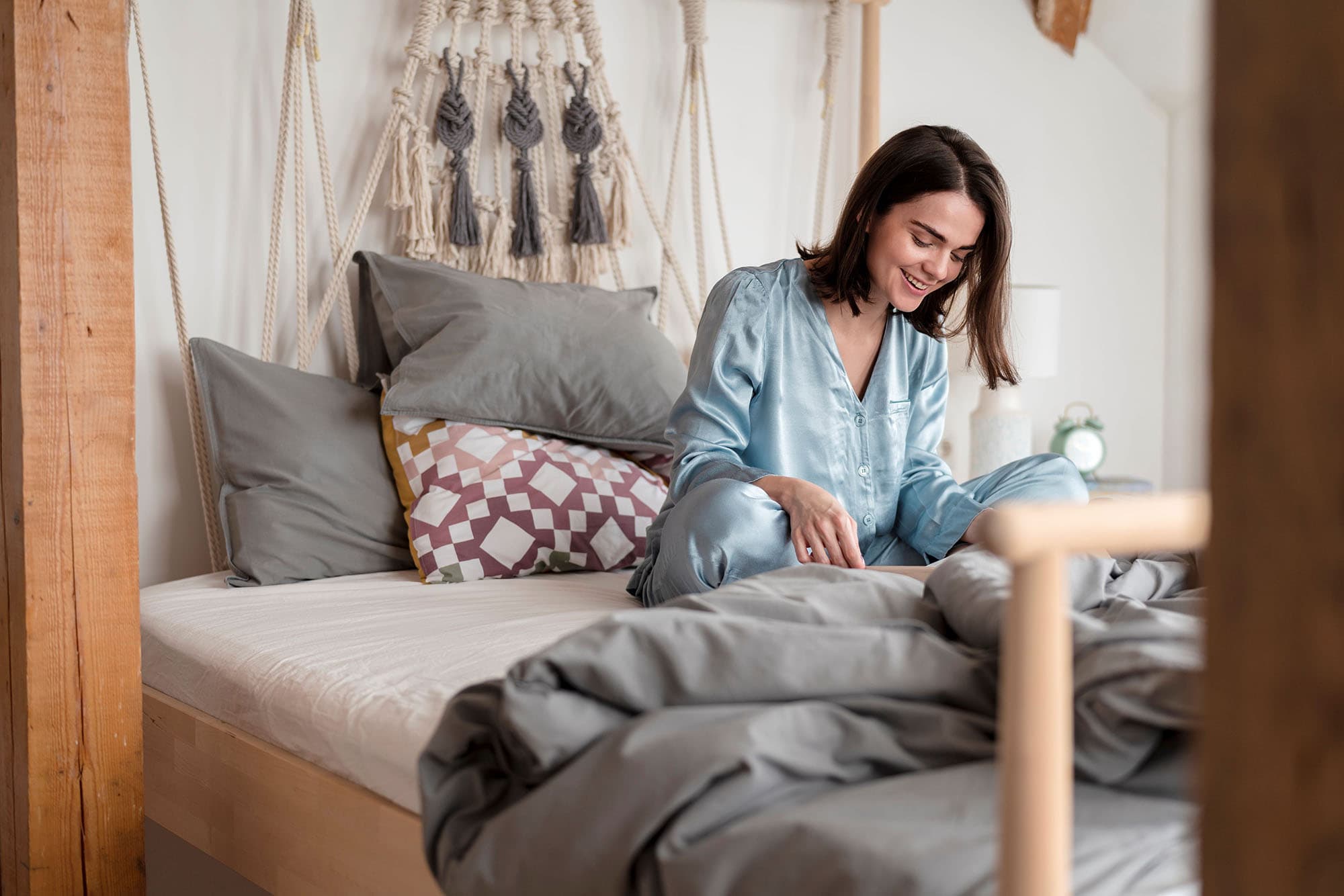 Woman waking up refreshed in a calm, cosy bedroom.