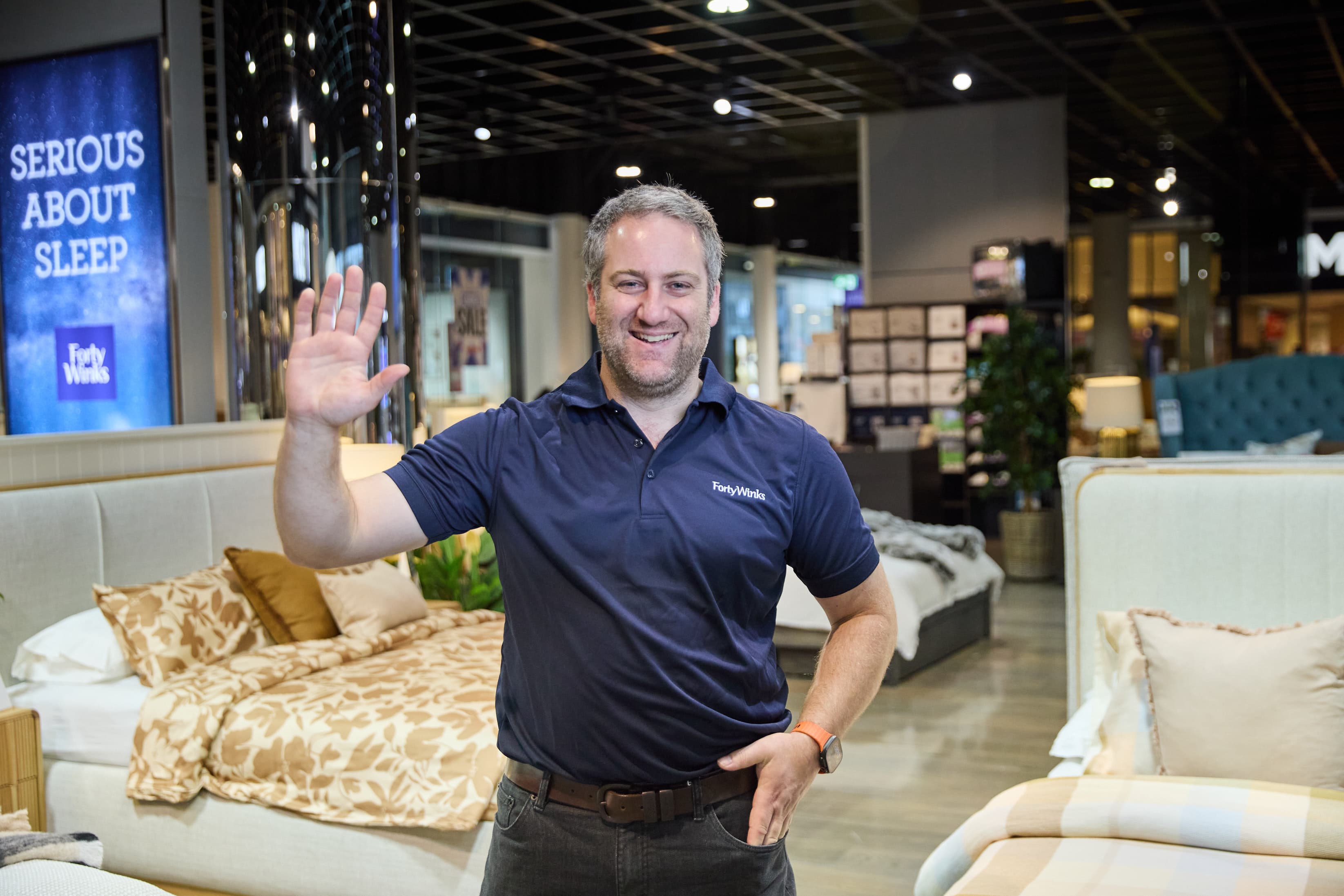 Forty Winks team member waving hello in store.