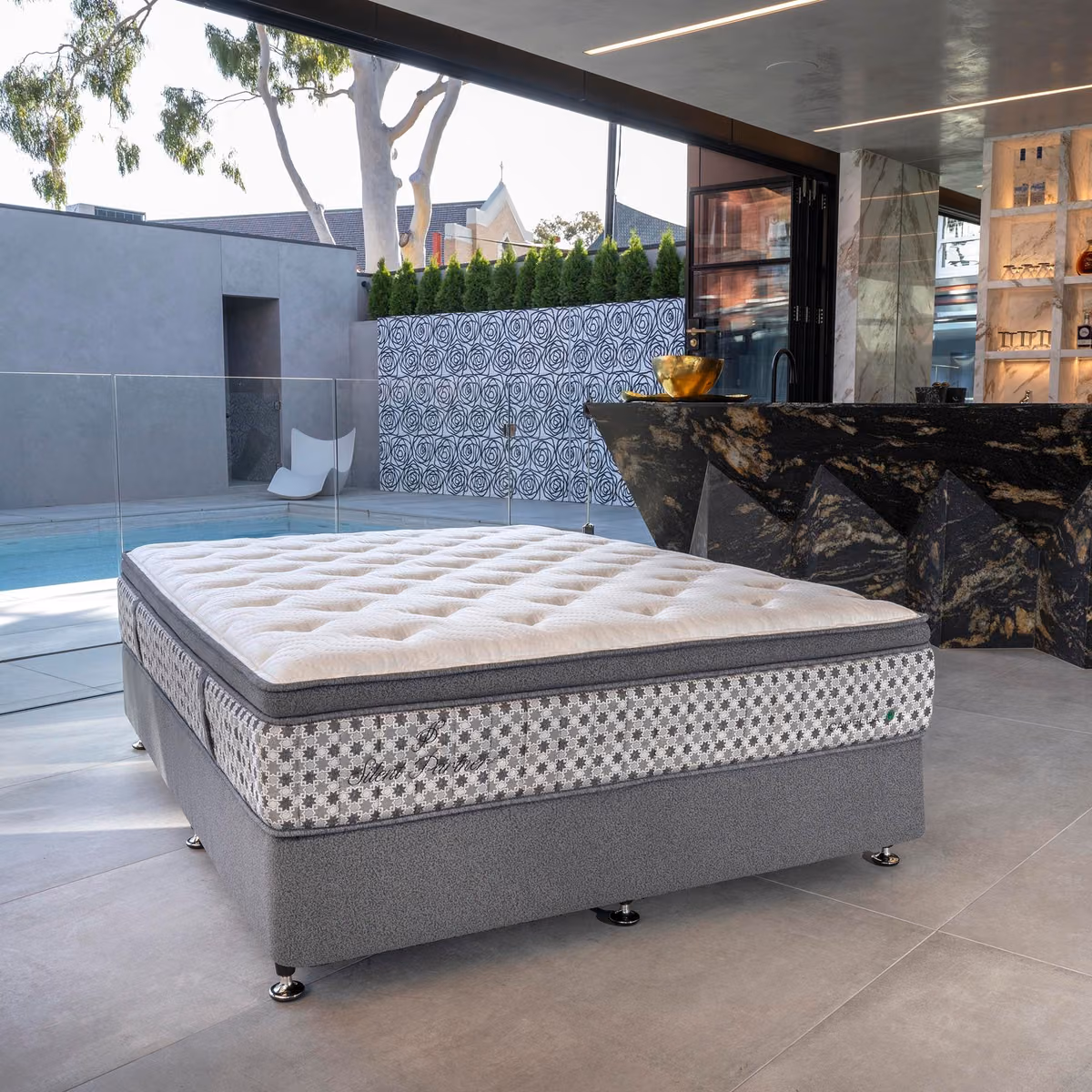 Silent Partner mattress and base beside an outdoor pool.