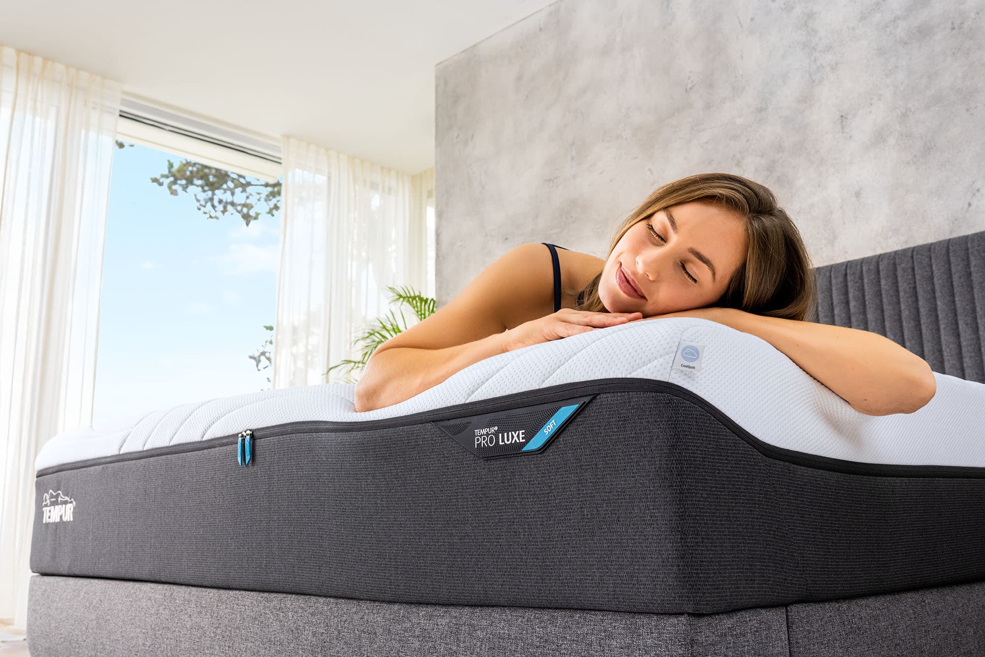 Woman resting her head on a TEMPUR® Pro Luxe mattress.