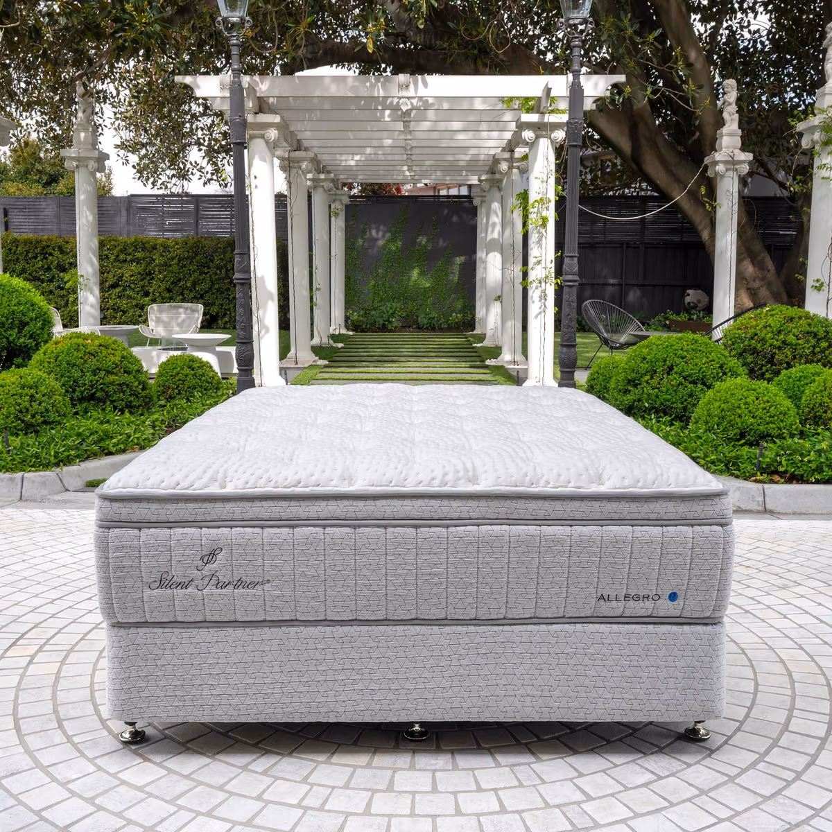 Silent Partner mattress and base set in a landscaped garden.